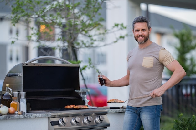 Middle aged man preparing barbecue grill outdoor man cooking barbecue grill at backyard chef prepari