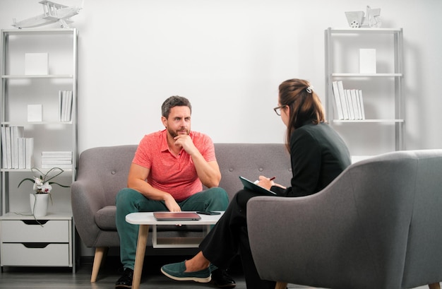 middle aged man problem therapy handsome man is sitting on couch and talking to the psychologist