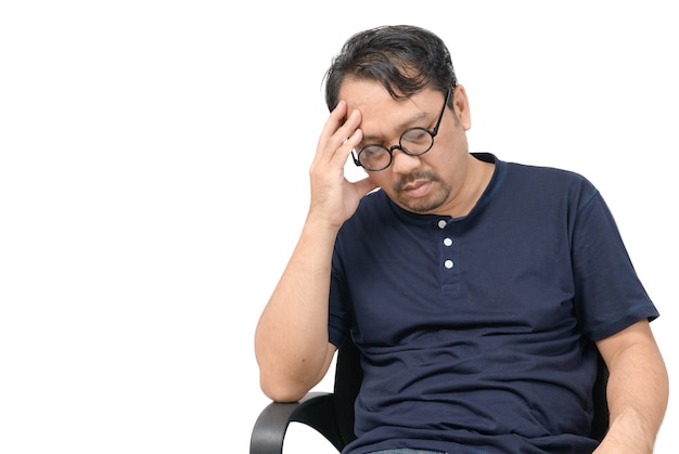 椅子に座ってストレスを感じ、頭痛が孤立している中年男性。問題とヘルスケアの概念。