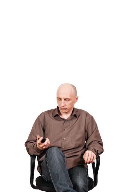 Middle-aged man sitting in an office chair, looking at smartphone screen