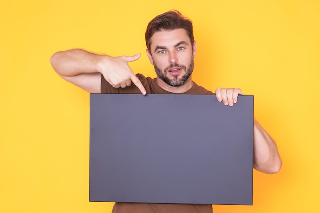 Middle aged man with blank placard demonstrating copy space for your text or design man showing empt