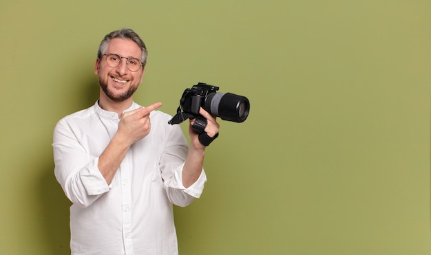 Middle aged photographer man holding camera