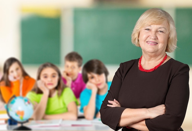 Middle aged teacher and kids in classroom