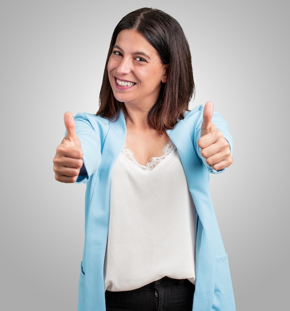 Middle aged woman cheerful and excited, smiling and raising her thumb up