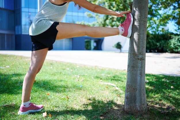 屋外でストレッチ運動をしている中年女性