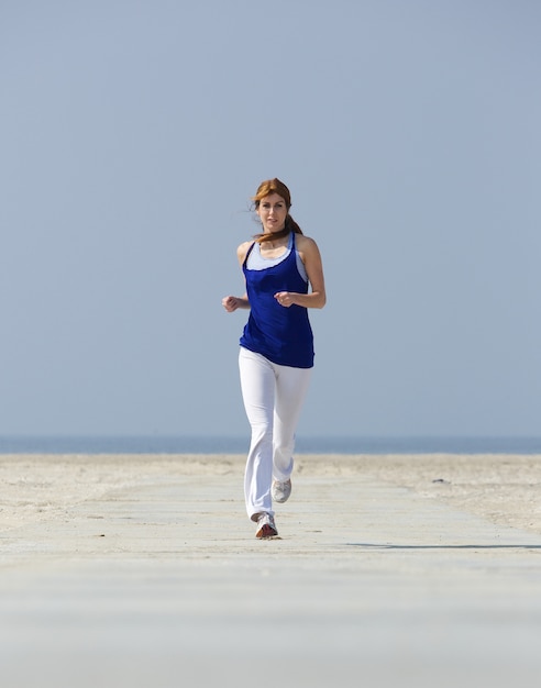 Middle aged woman jogging at the beach