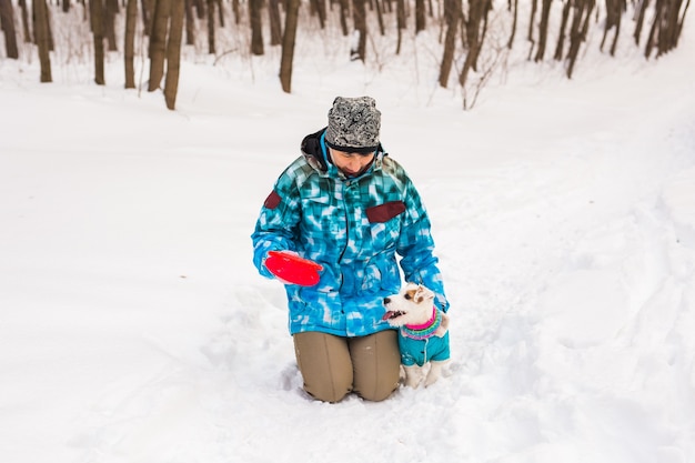 Donna di mezza età all'aperto con simpatico cane - jack russell terrier nella stagione invernale