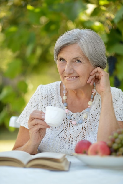 Middle-aged woman reading a book and drink tea