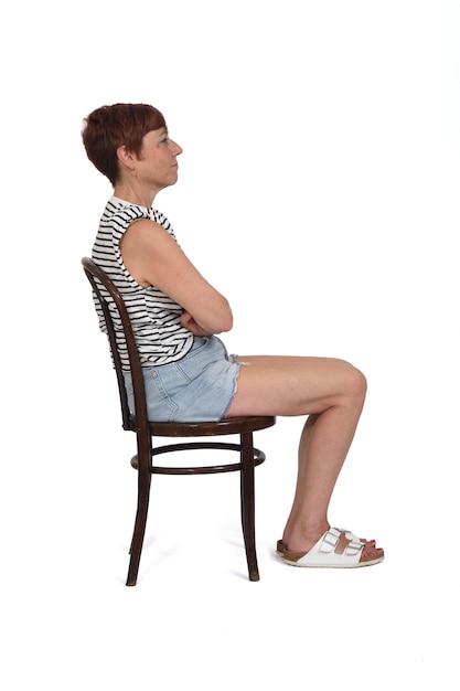 Middle aged woman sitting on chair serious and arms crossed on white background