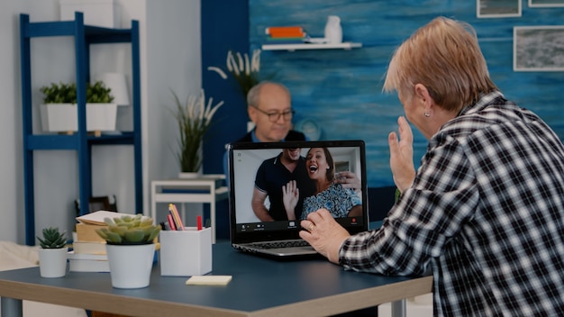 Middle aged woman talking video conference with children calling on laptop senior old distance mothe...