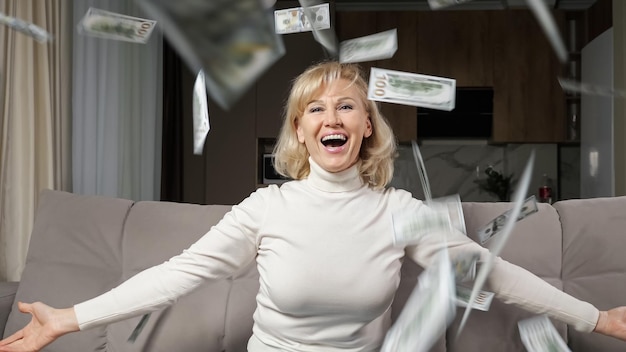 Middle aged woman tosses bills of pension in air of room