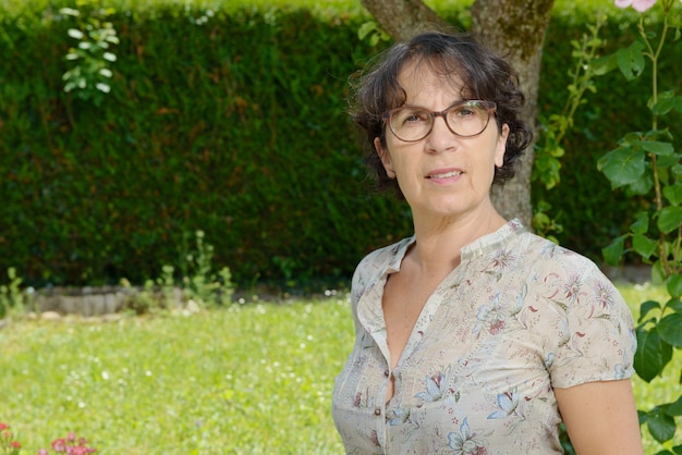 Middle-aged woman with glasses in the garden