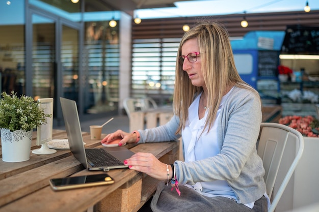 Donna di mezza età che lavora su un computer portatile