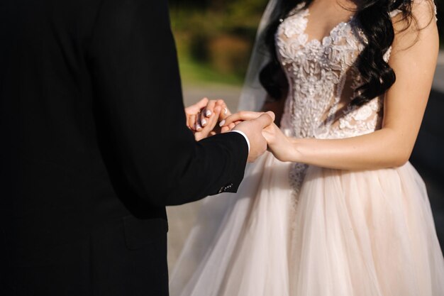 Middle celection of groom and bride take each others hands outdoors wedding concept