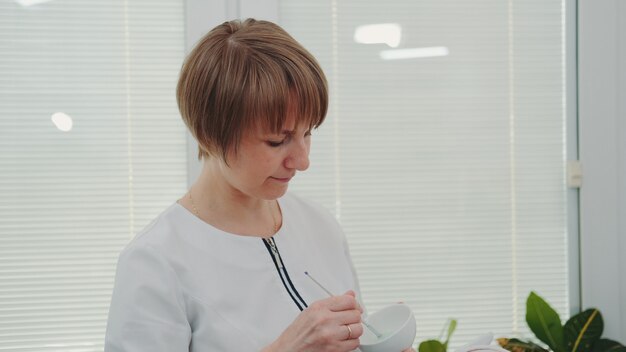 Средний крупный план веселого косметолога, работающего в салоне красоты