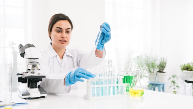 Middle East woman scientist researcher use a lab dropper to drip a substance into a test tube for analysis of liquids in the lab Scientist working with a dropper and a test tube