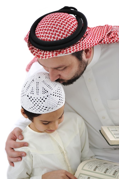 Middle eastern education, father kissing son while reading Koran