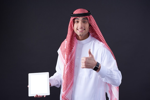 Middle Eastern man posing with white tablet isolated.
