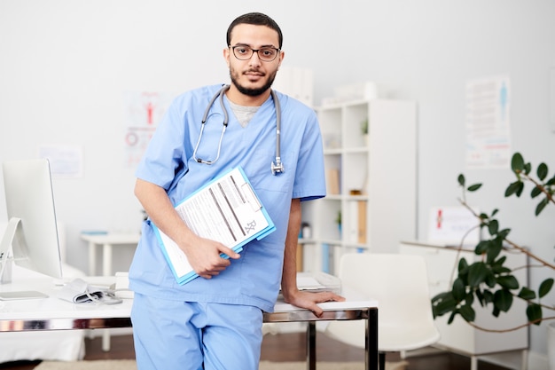 Foto medico mediorientale in posa in ufficio