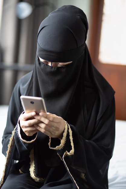 Middle eastern saudi arabian muslim woman using smartphone or smartphone app