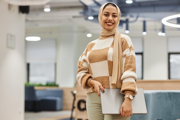 Middle eastern woman wearing head cover standing in office