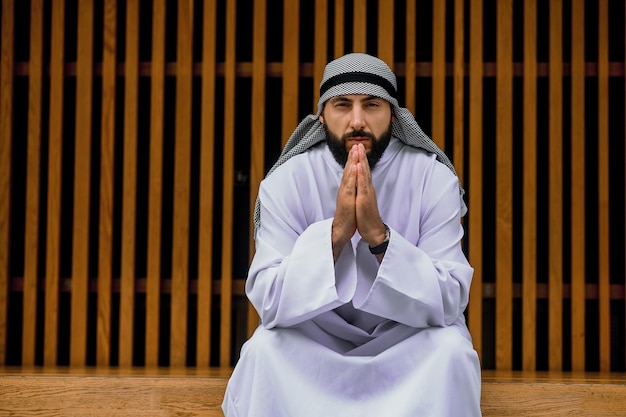 Middle eastern young man in traditional clothing looking thoughtful and concentrated