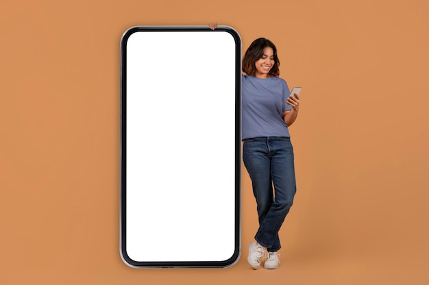 Photo middle eastern young woman stand next to big phone