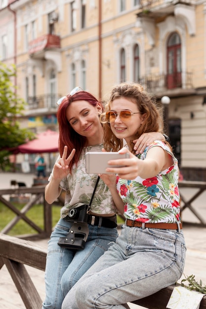 Middle shot females taking selfie in city centre