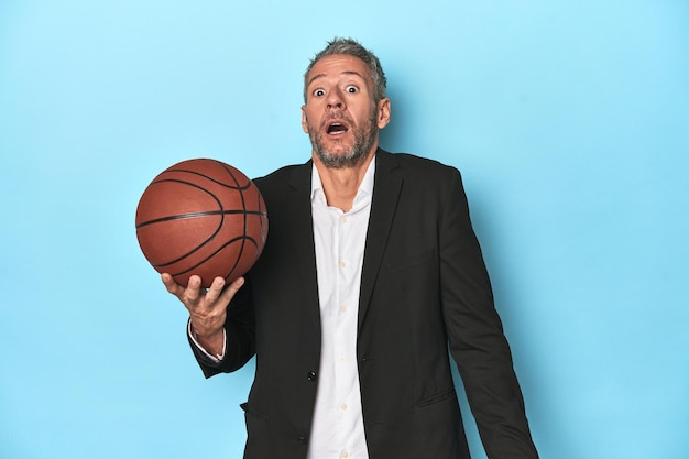 Middleaged basketball coach on blue backdrop