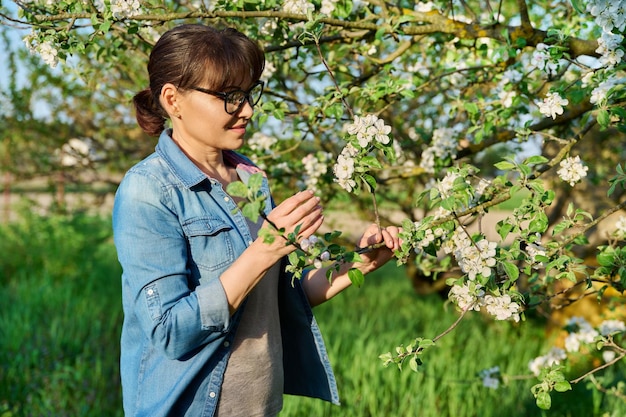 Middleaged beautiful woman in a blooming garden