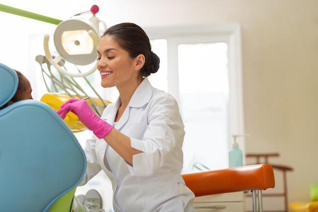 Dentista femminile caucasico di mezza età che esegue un esame dentale