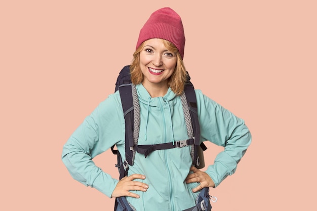 Middleaged Caucasian woman with hiking gear confident keeping hands on hips