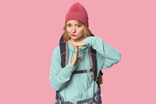 Middleaged Caucasian woman with hiking gear showing a timeout gesture