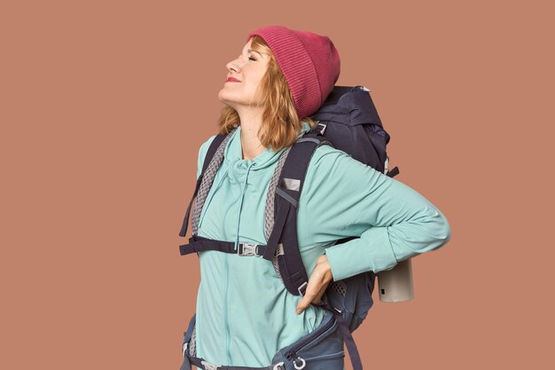 Photo middleaged caucasian woman with hiking gear suffering a back pain