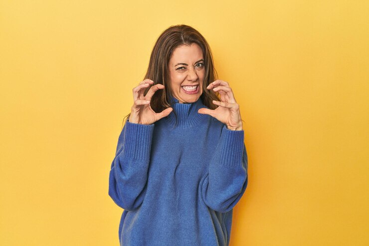Photo middleaged caucasian woman on yellow upset screaming with tense hands