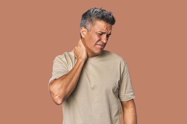 Middleaged Latino man having a neck pain due to stress massaging and touching it with hand