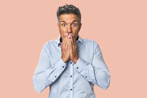 Photo middleaged latino man shocked covering mouth with hands anxious to discover something new