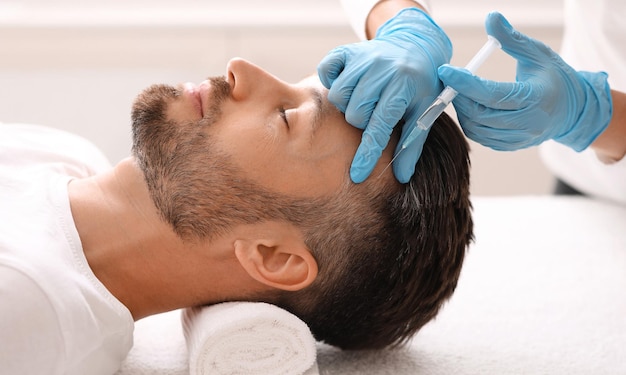 Middleaged man having hair treatment at beauty salon