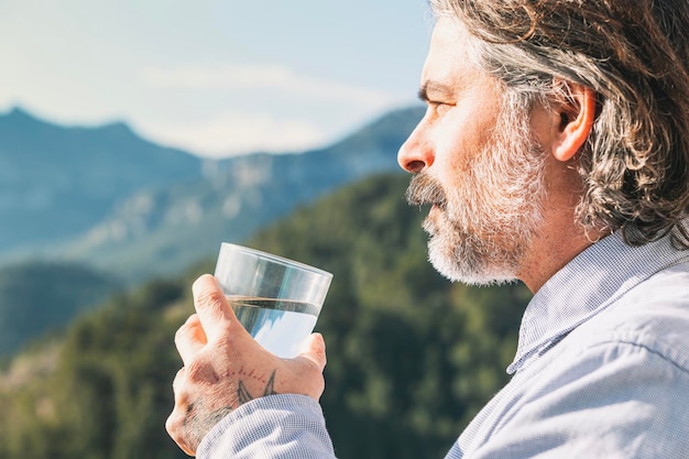 Uomo di mezza età che tiene un bicchiere d'acqua