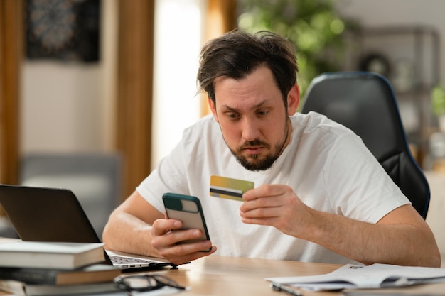 Photo a middleaged man is trying to make purchase online he carefully enters his bank card