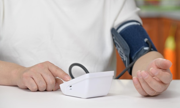 Middleaged man using blood pressure monitor