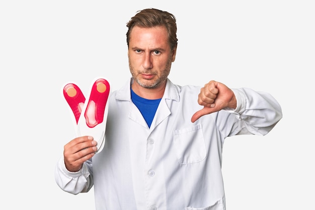 A middleaged podiatrist holding an insoles