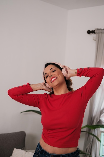 Middleaged woman enjoying music with headphones and dancing alone Concept happiness fun