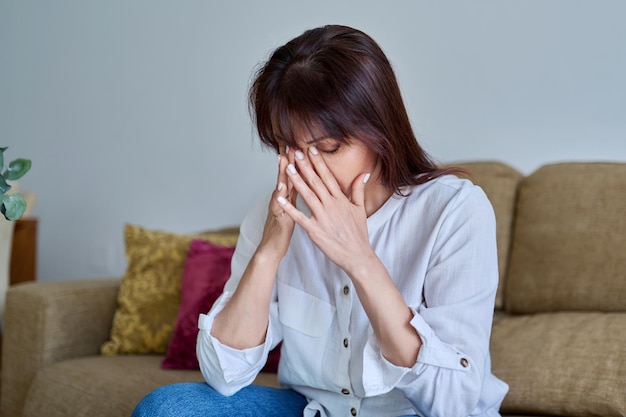 Middleaged woman experiencing stress difficulties headache