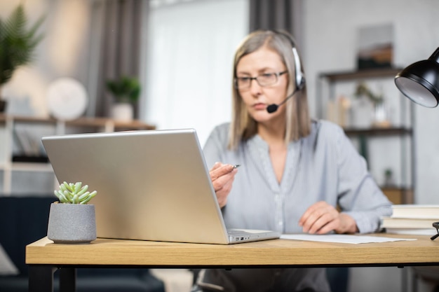 Middleaged woman holding online conference at remote work