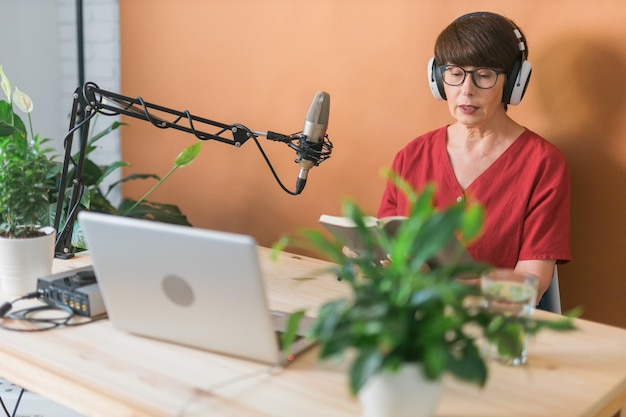 Middleaged woman radio host making podcast recording for online show broadcast and dj concept