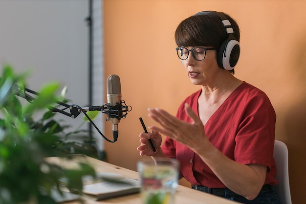 Middleaged woman radio host making podcast recording for online show broadcast and dj concept