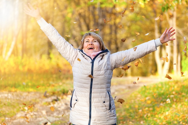 A middleaged woman walks in an autumn Park she is beautiful and happy