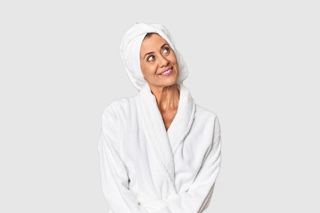 Middleaged woman with towel postshower in studio dreaming of achieving goals and purposes