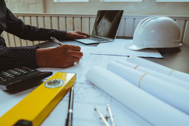 Photo midsection of architect preparing blueprint on desk